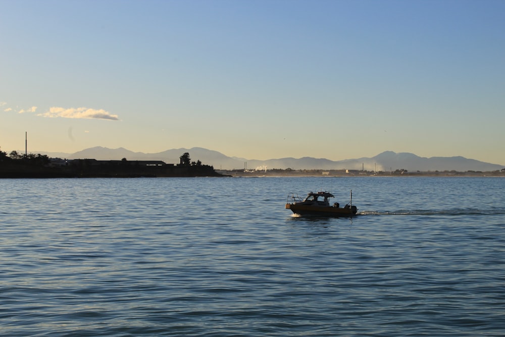 silhouette of boat on sea during daytime