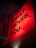 A neon red sign with the words #DO WHAT MOVES YOU mounted on a textured wall. The letters are bold and three-dimensional, casting shadows on the wall, and illuminated against the dark surroundings.