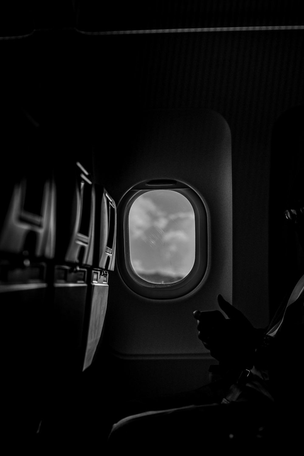 Foto in scala di grigi del finestrino dell'aeroplano