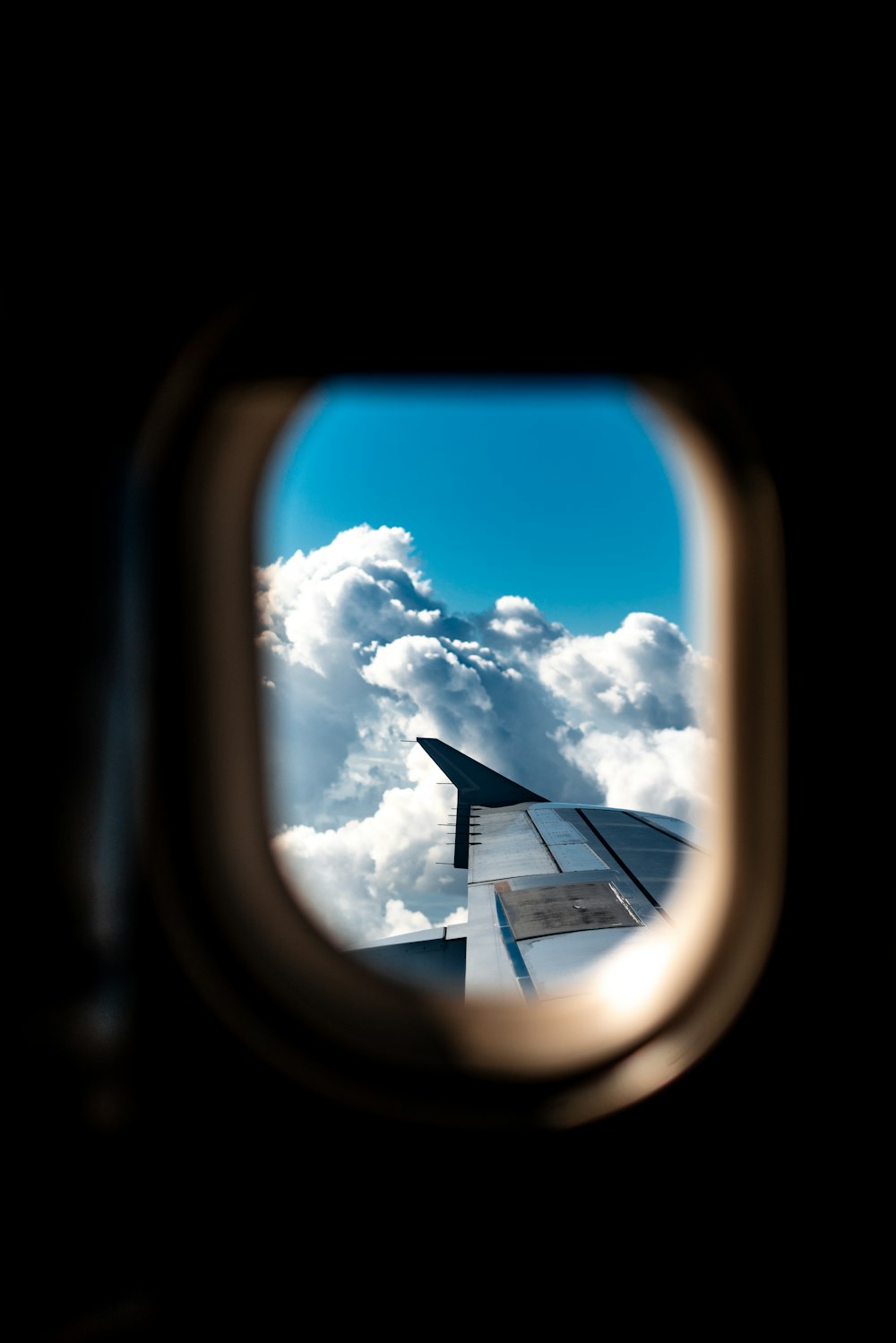 ala de avión bajo nubes blancas durante el día