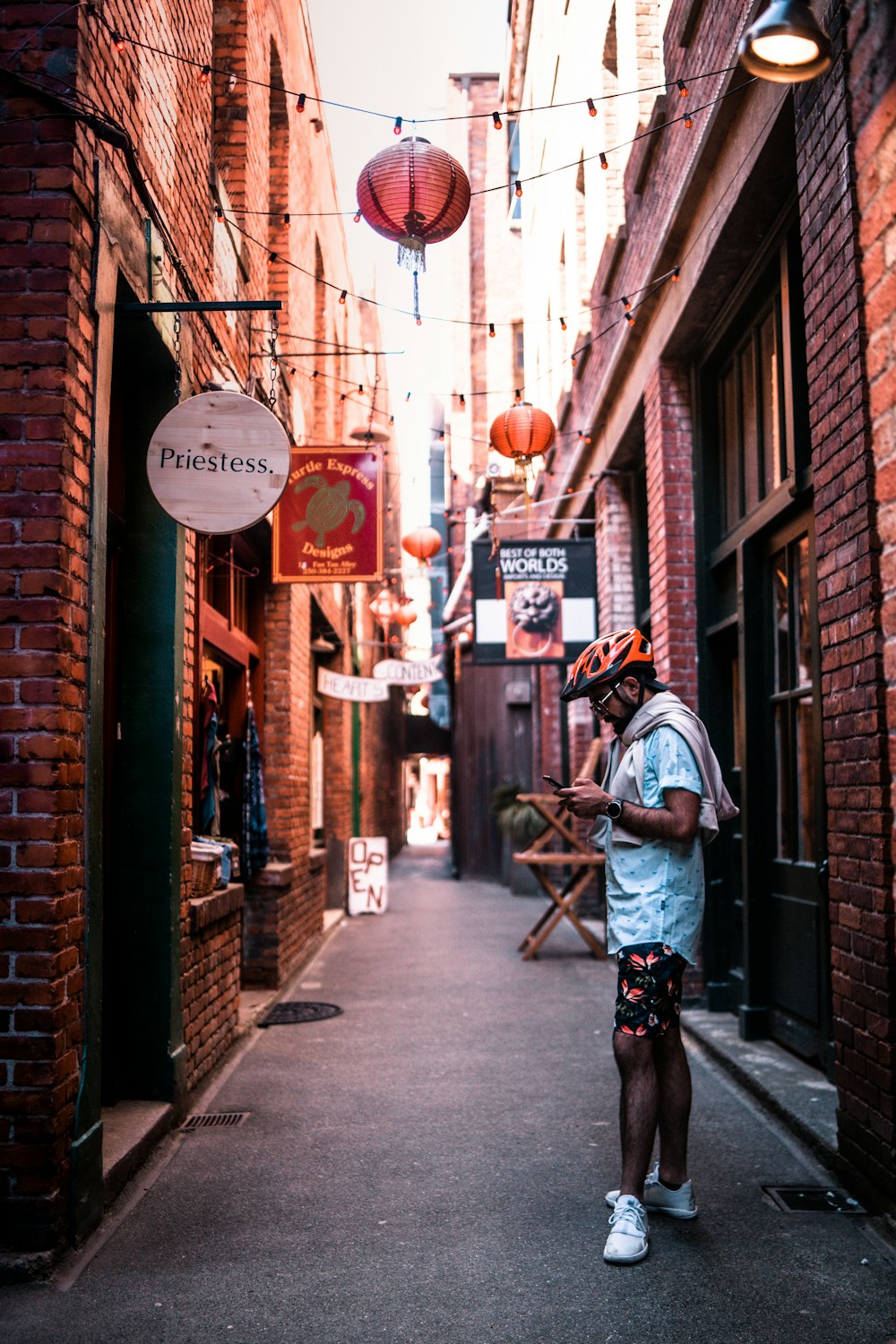 man in white jacket and black pants walking on sidewalk during daytime