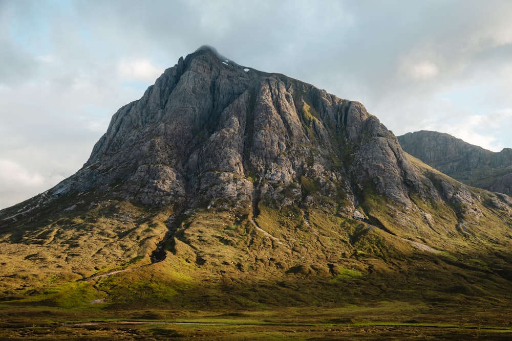 brown and green mountain under white clouds during daytime