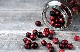 red round fruits in clear glass jar