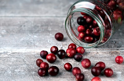 red round fruits in clear glass jar cranberries google meet background