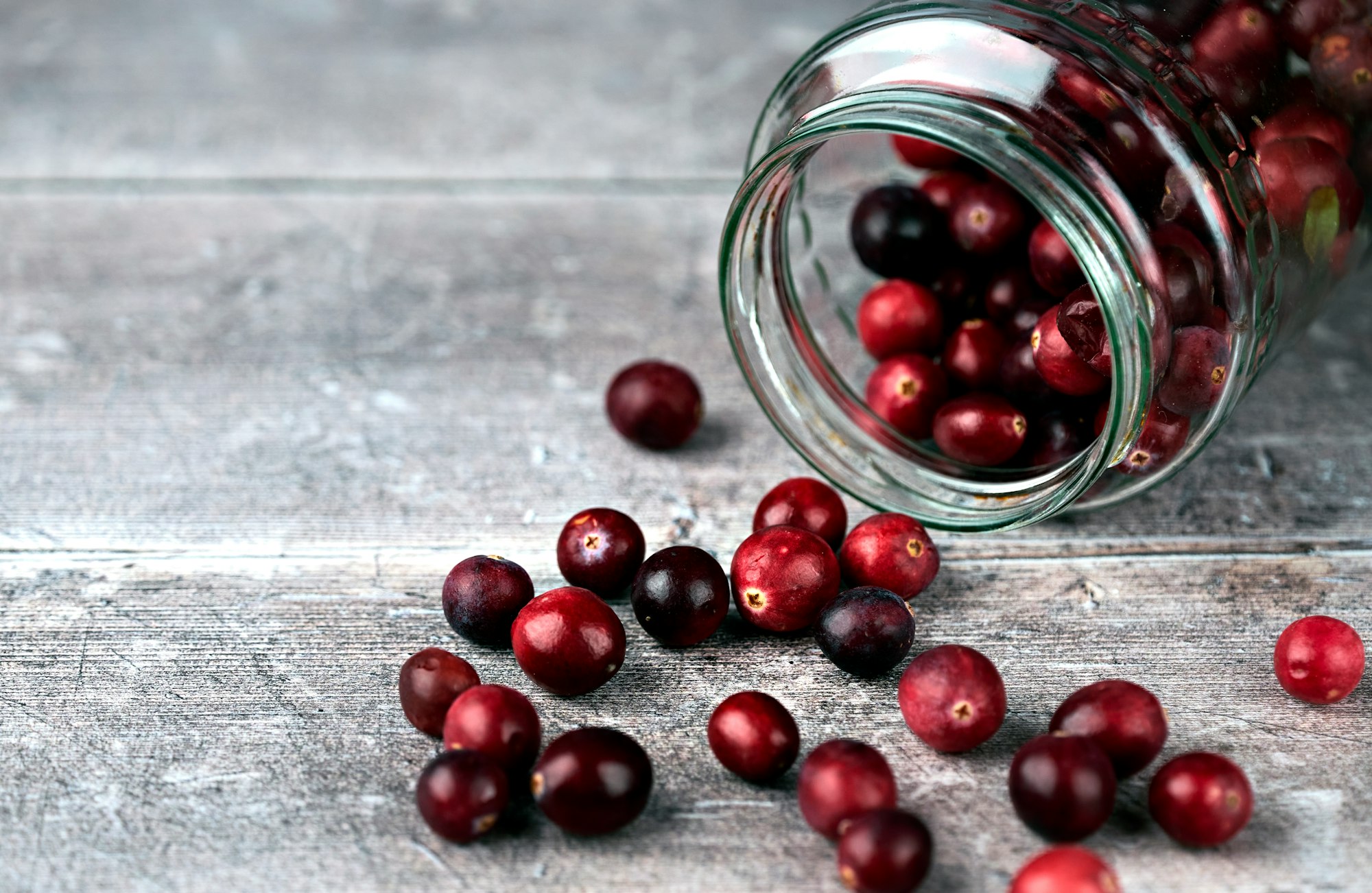 Jar and cranberries. Selective focus on cranberries and jar sides. Close up