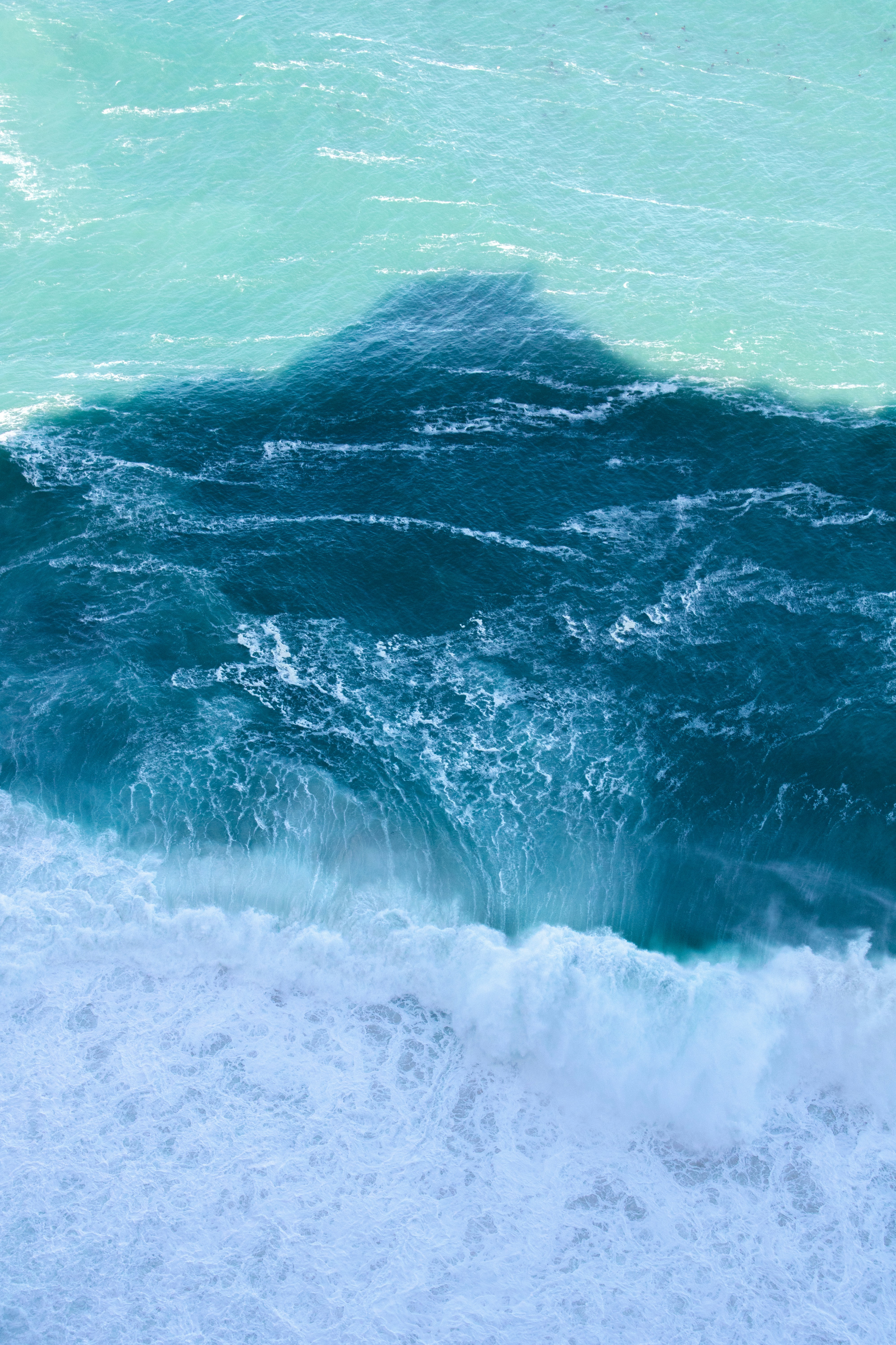 Sunlit ocean waves with clean turquoise water, bright natural daylight, open sea horizon