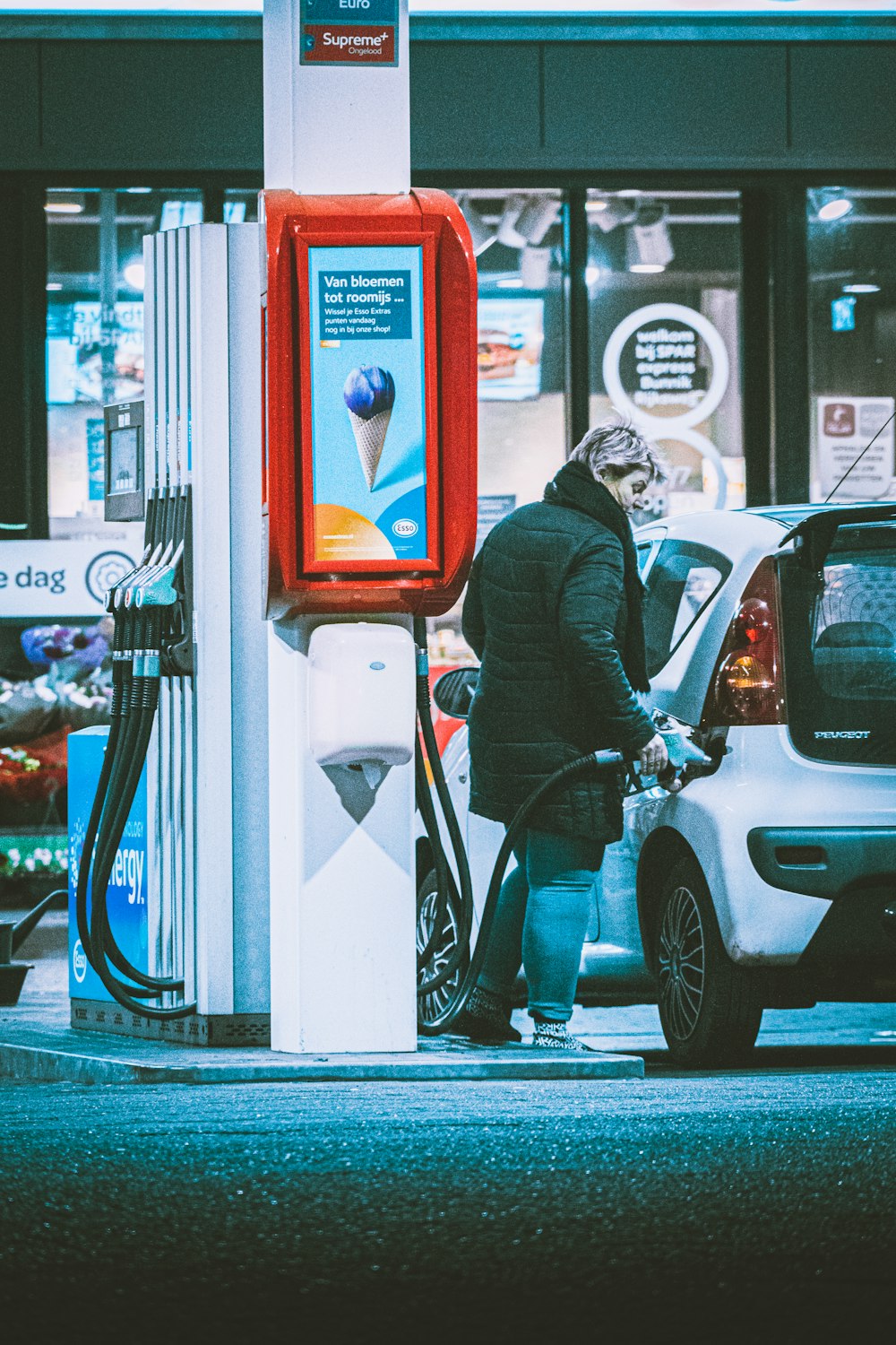 man in black suit standing beside white car