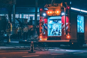 Group of firefighters loading gear onto a Pavoni fire truck at sunset