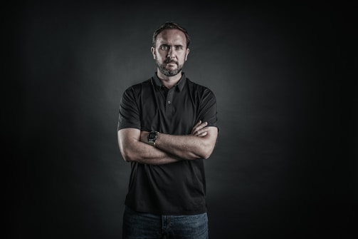 man in black polo shirt and blue denim jeans