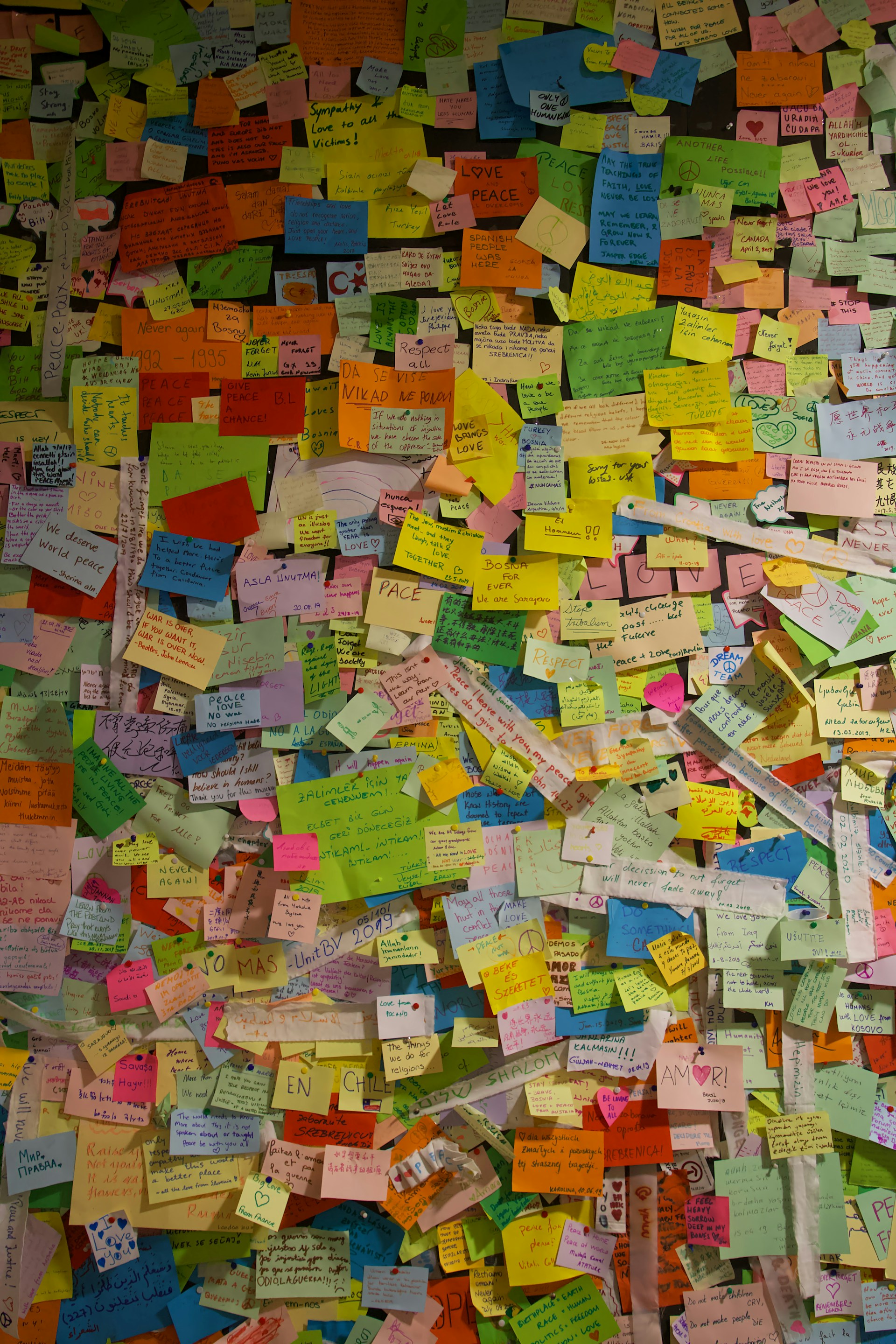 A colorful collage of handwritten notes and photos pinned on a wall, showcasing heartfelt messages from Allens around the world.