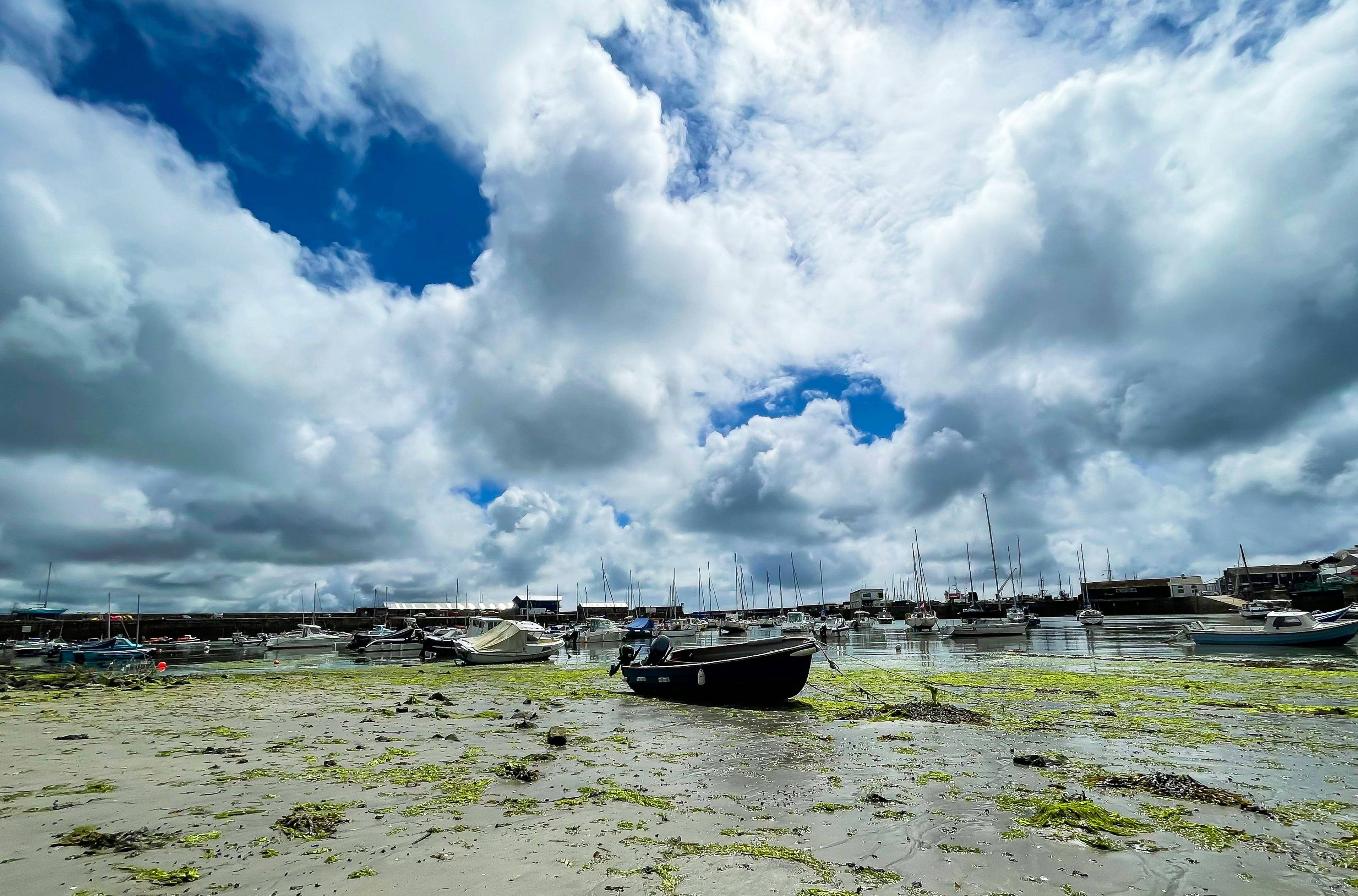 white and black boat on sea under white clouds and blue sky during daytime