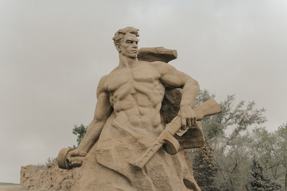 man holding cross statue during daytime