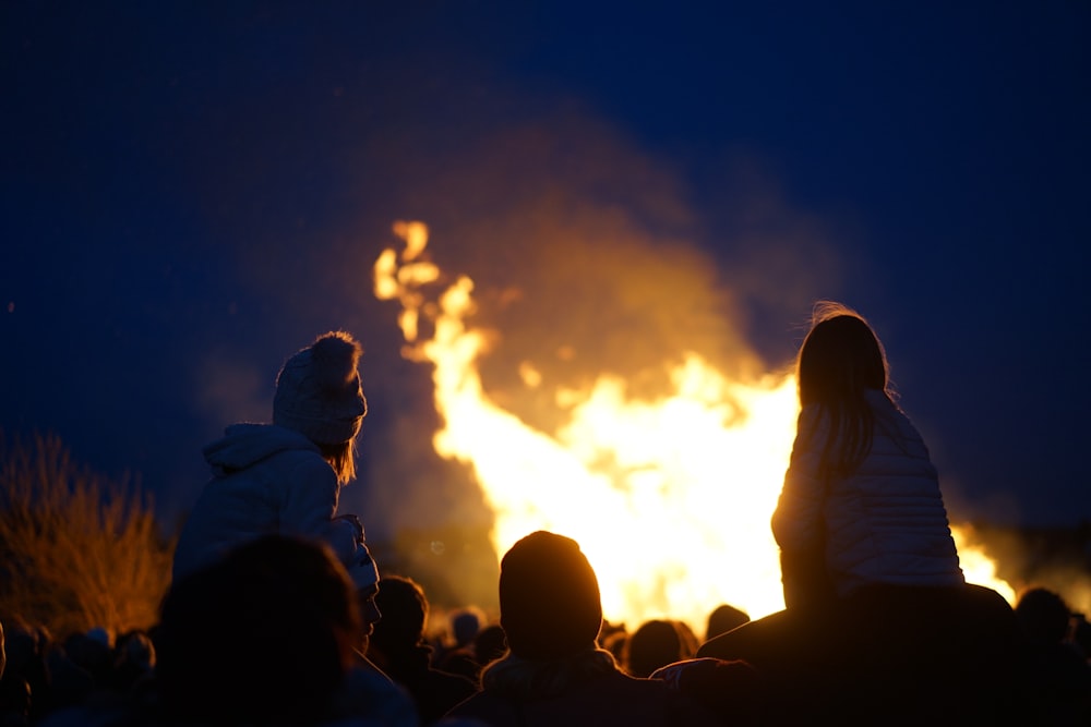 silhouette of people watching fire during night time