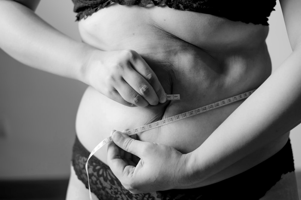 Photo en niveaux de gris d’une femme tenant son sein