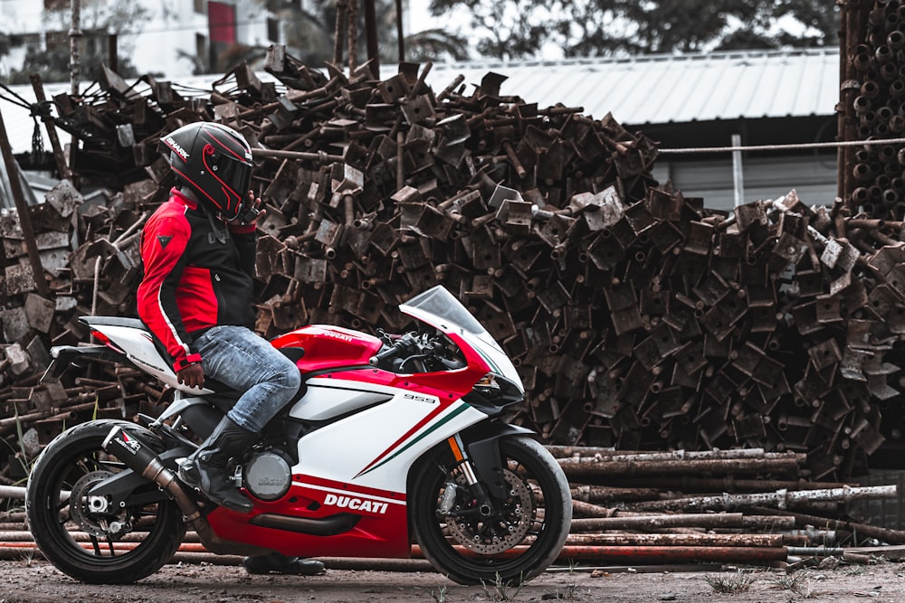 man in red and black motorcycle helmet riding red and black sports bike