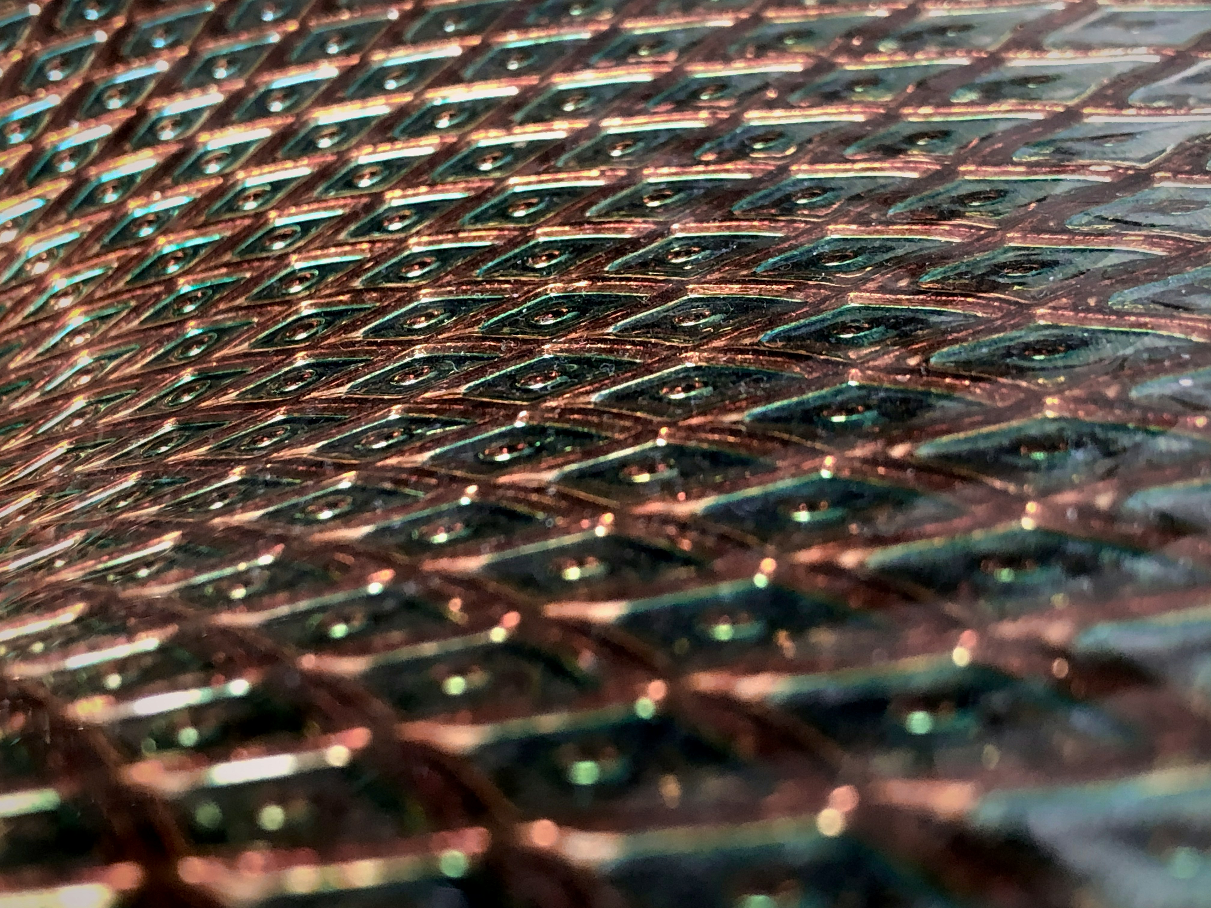 close-up of a digital tablet showing a world map with glowing supply chain routes, a copper wire coil bundle in the blurred background, blue technical interface overlay