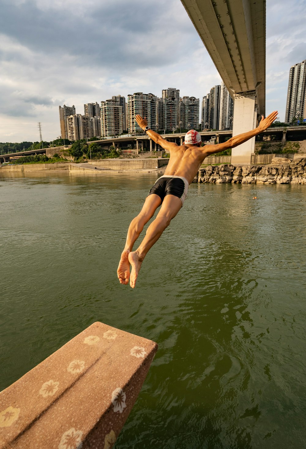 man in black shorts jumping on water during daytime