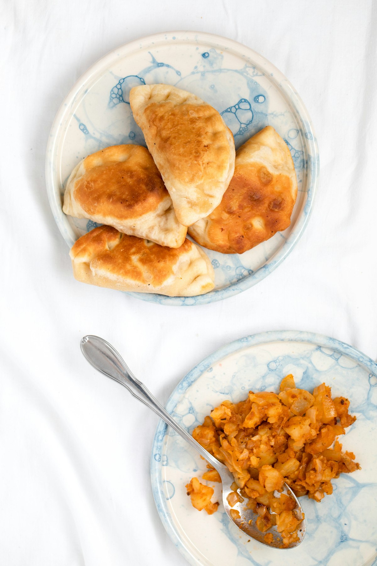 Golden baked Argentine beef empanadas with hand-crimped repulgue edge on a wooden board