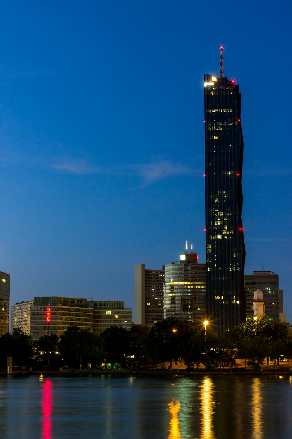 city skyline under blue sky during night time