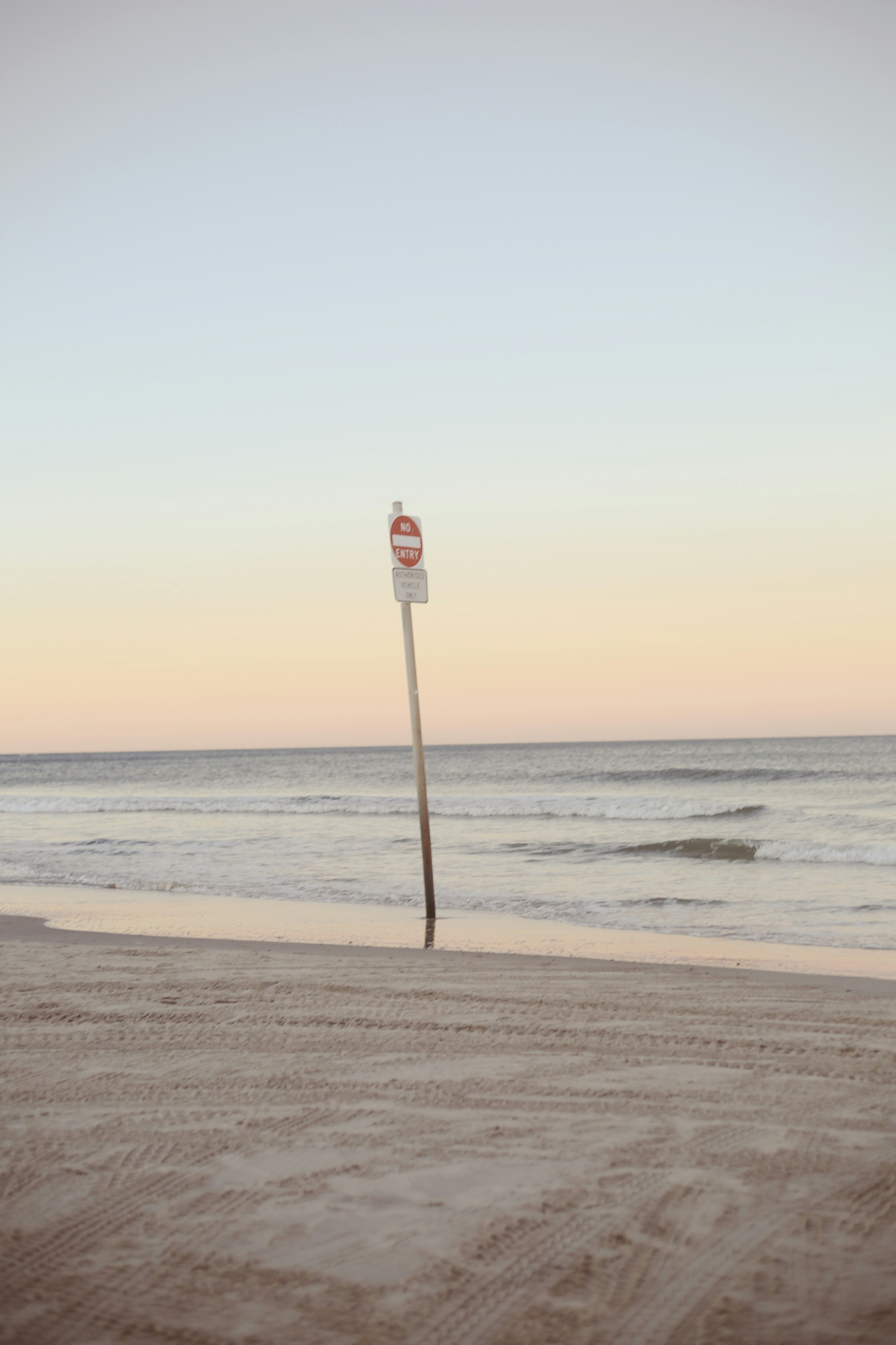 white and red light post on beach during daytime