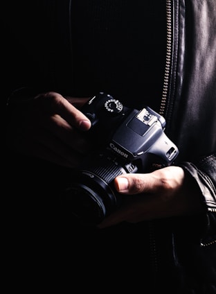 person holding black dslr camera
