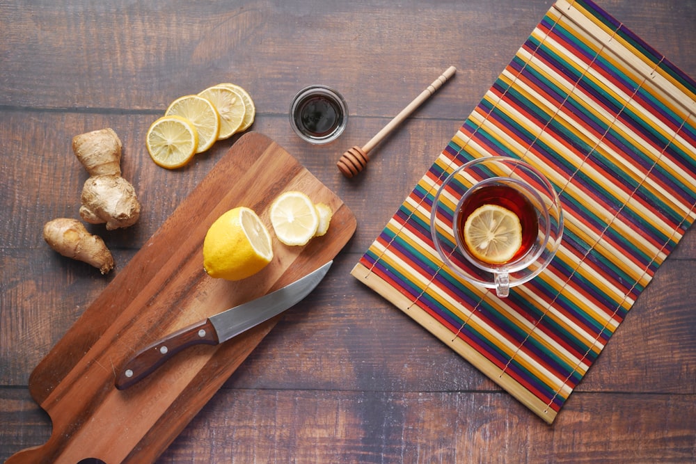 sliced lemon on chopping board beside knife and fork