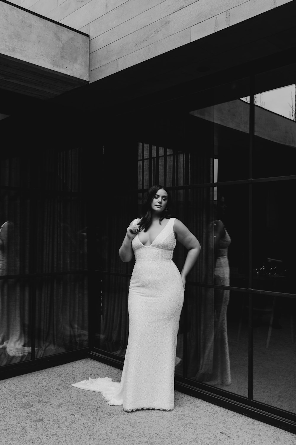 woman in white spaghetti strap dress standing in front of window