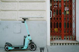 blue and black motorcycle parked beside red and white wall