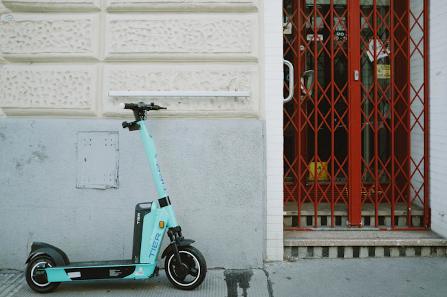 blue and black motorcycle parked beside red and white wall