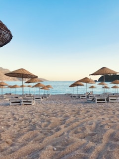 A serene beach setting with elegant lounge chairs and umbrellas.