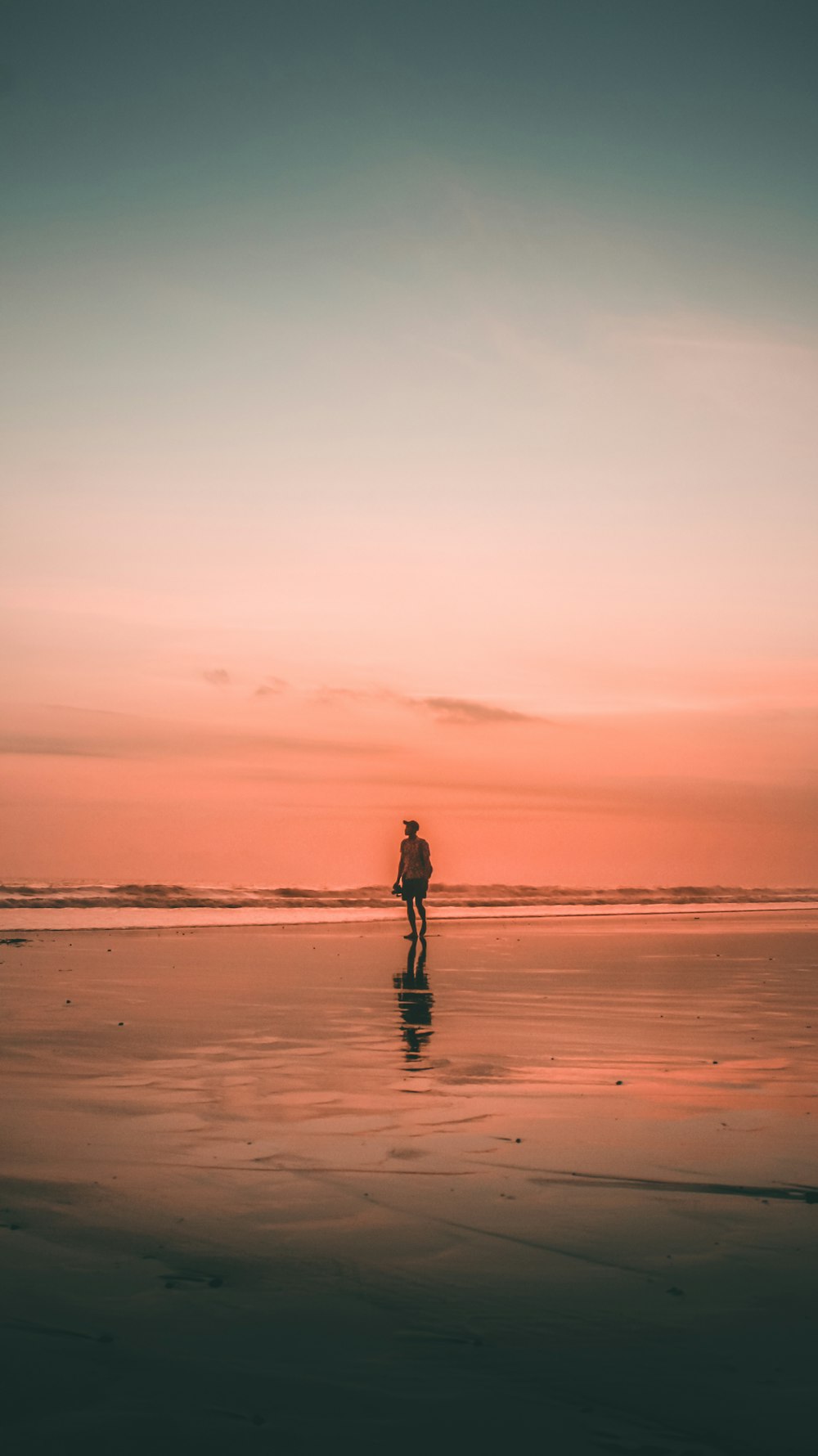 silhouette of woman walking on beach during sunset