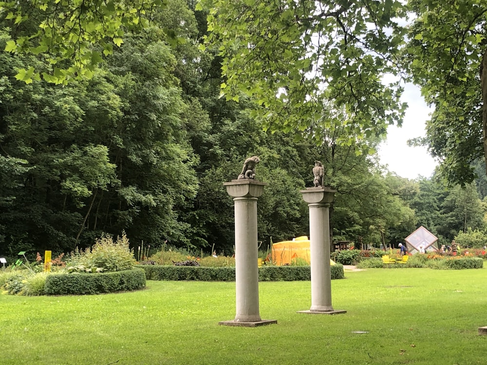 brown concrete outdoor fountain surrounded by green grass and trees during daytime