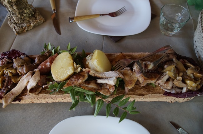 Grilled meals served on a rustic wooden table.