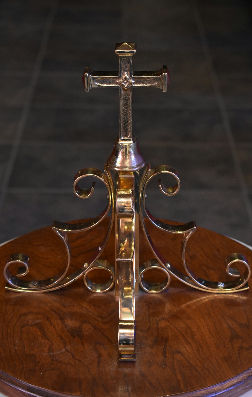 Cruz de oro sobre mesa de madera marrón