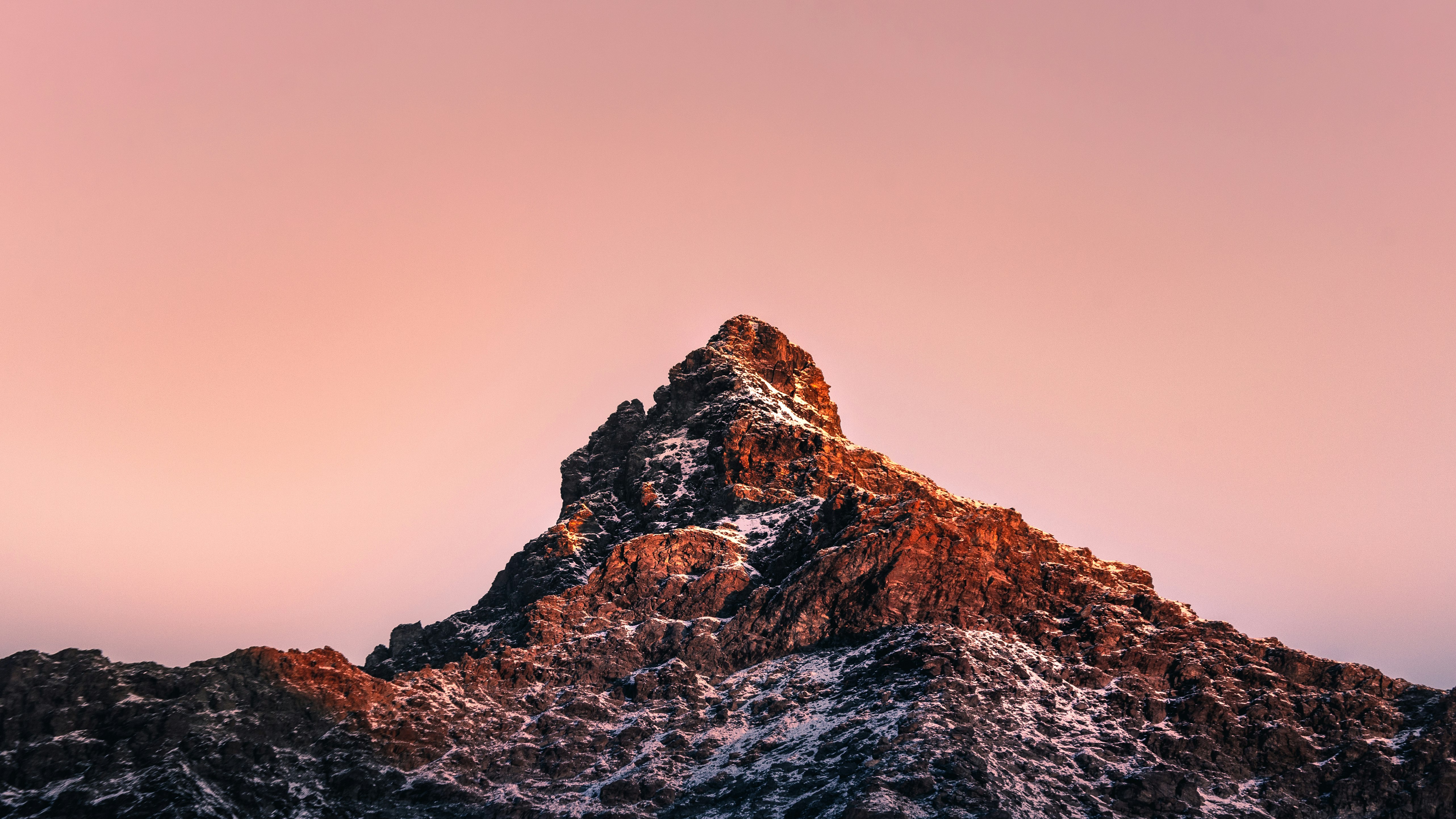 brown rocky mountain under gray sky