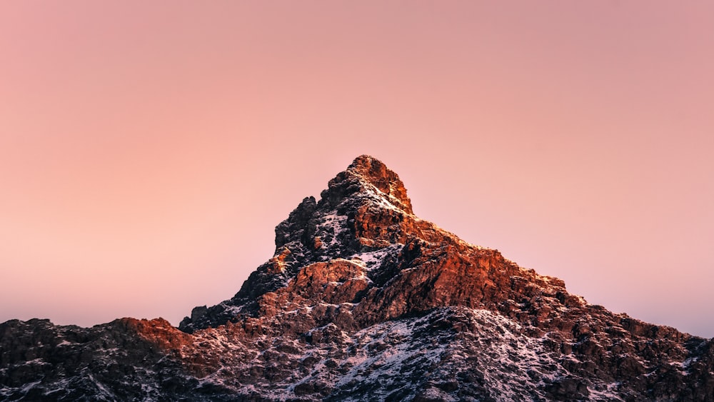 brown rocky mountain under gray sky