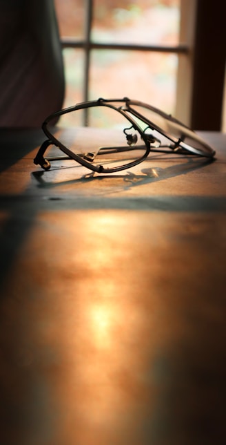 black framed eyeglasses on brown wooden table