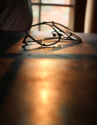 black framed eyeglasses on brown wooden table