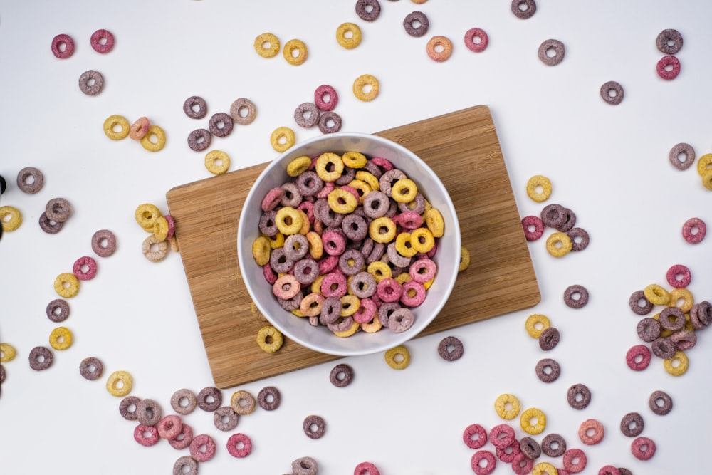 red and blue berries on white ceramic bowl on brown wooden chopping board