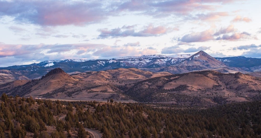 brown and green mountains under white clouds during daytime