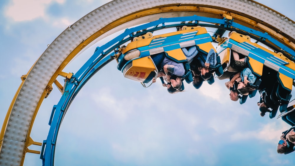 people riding roller coaster during daytime