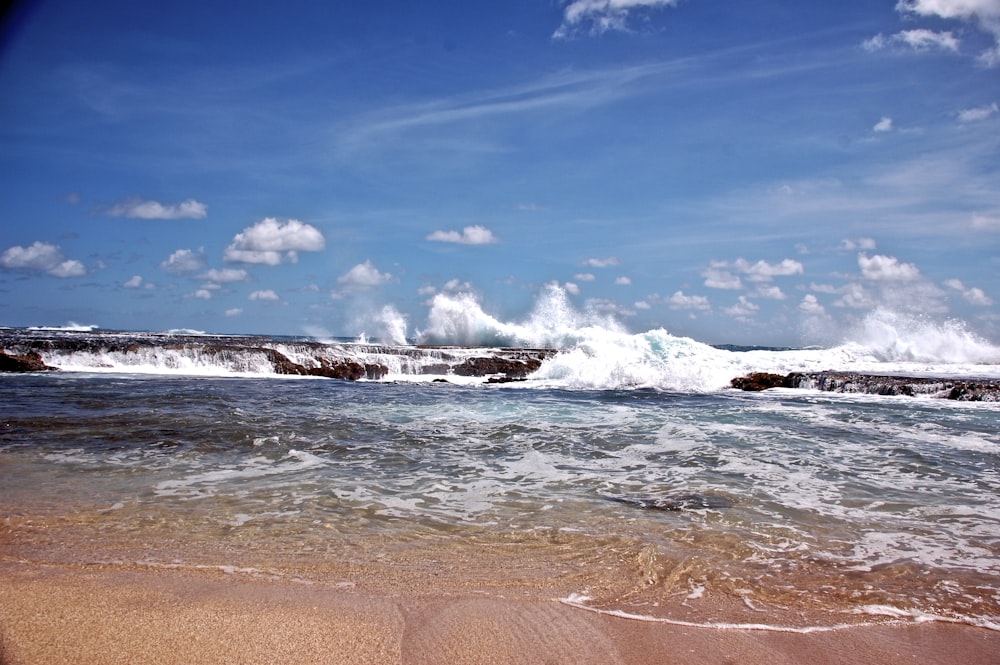 ocean waves crashing on shore during daytime