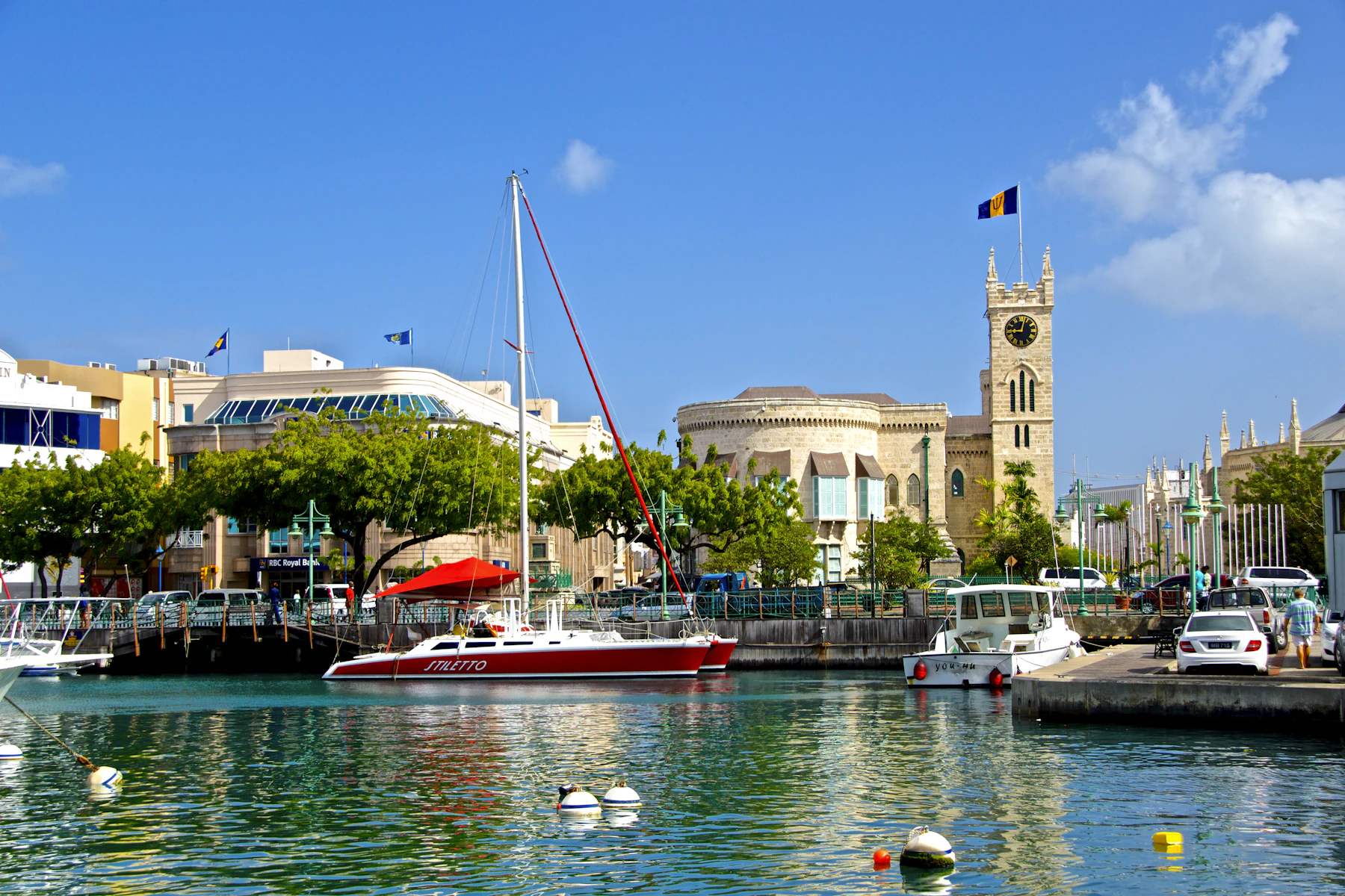 A red and white boat moored beside a waterfront building in Barbados