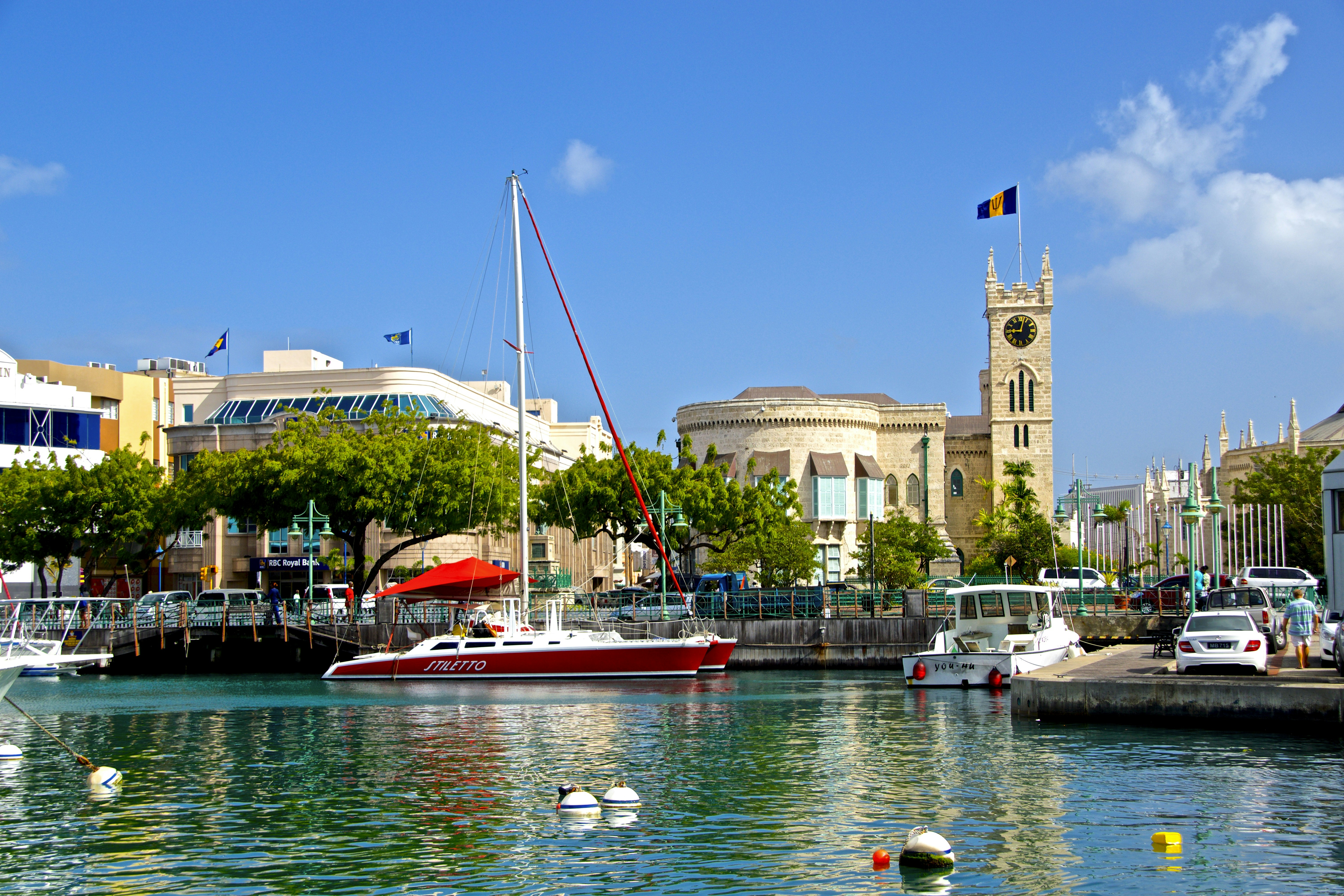 white and red boat on water near brown concrete building during daytime