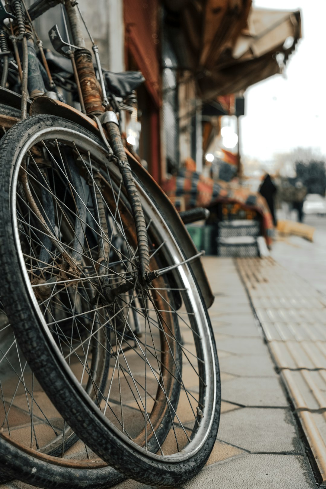 black bicycle wheel on sidewalk during daytime