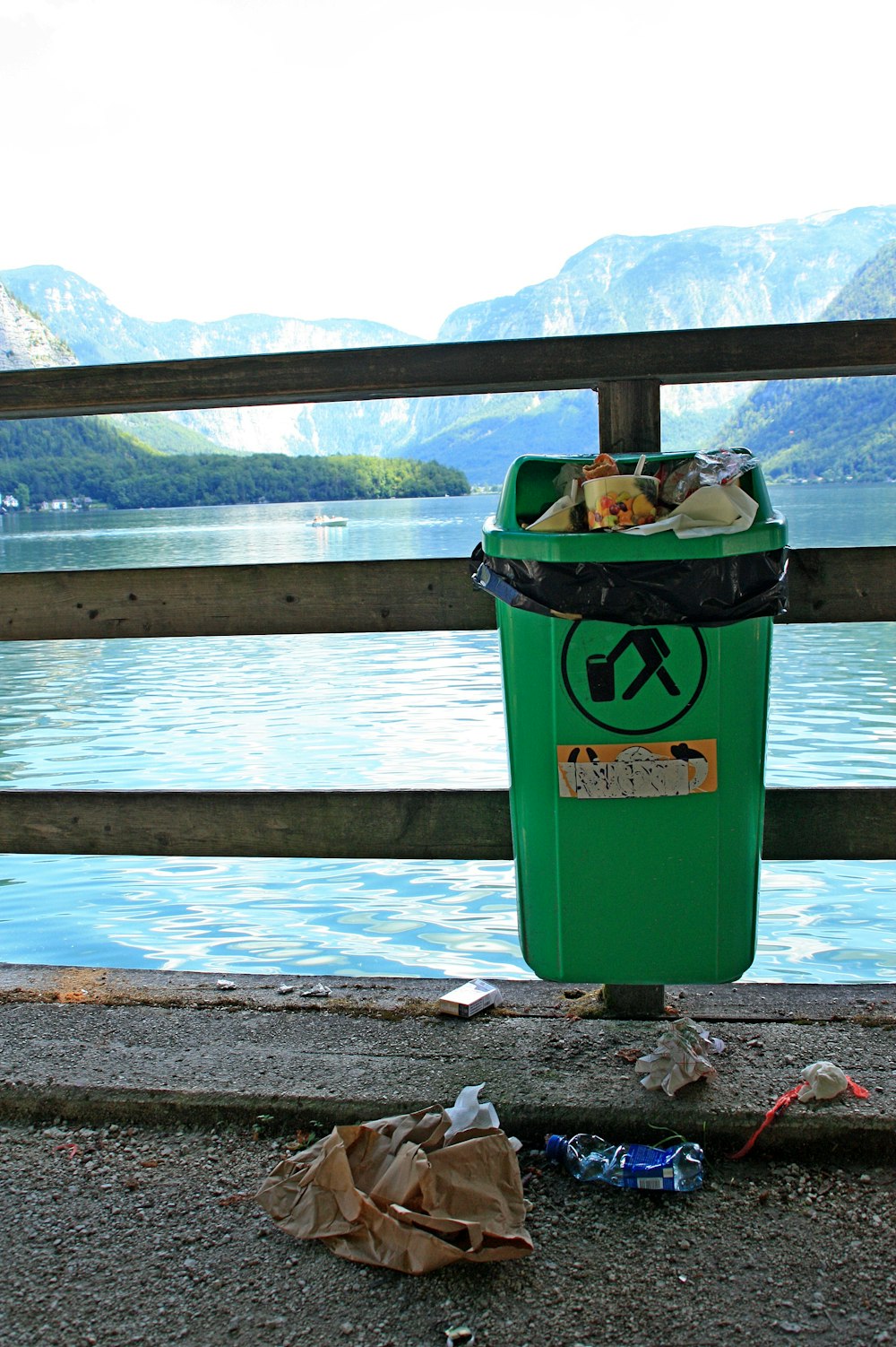 green trash bin on brown wooden dock during daytime