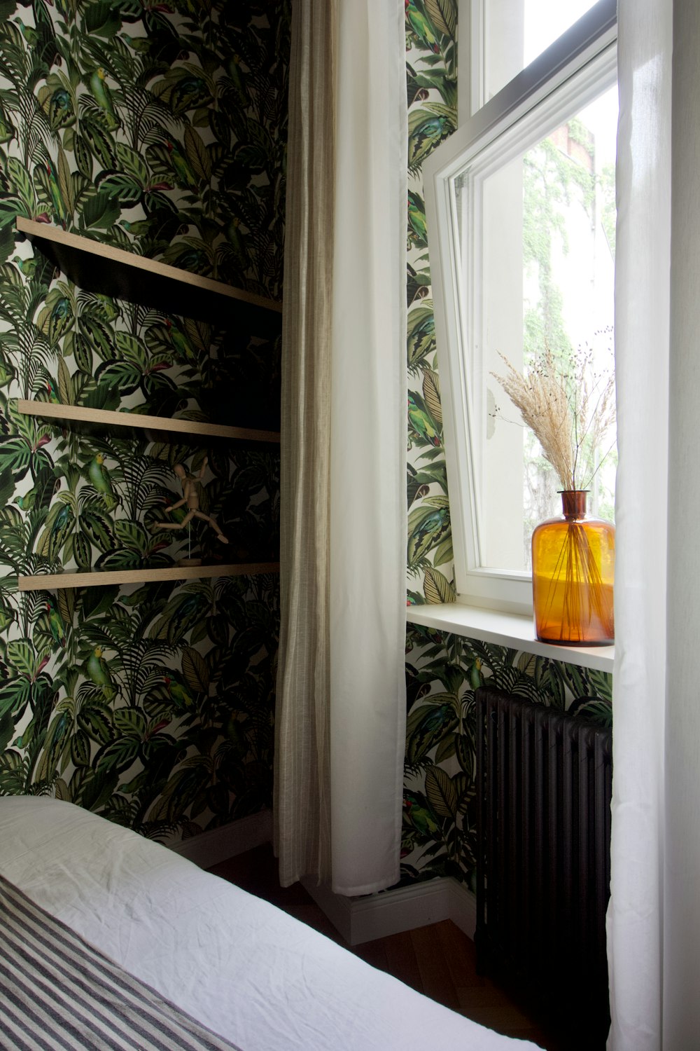 green plant in brown pot beside window