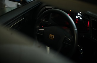black car steering wheel with red and yellow sticker