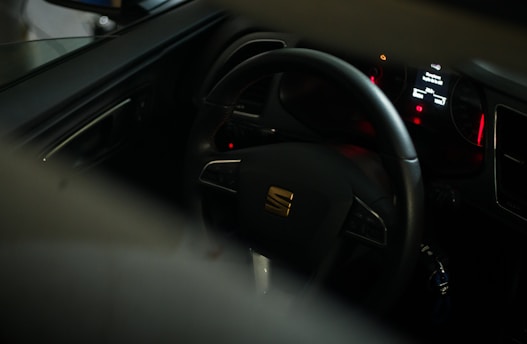 black car steering wheel with red and yellow sticker