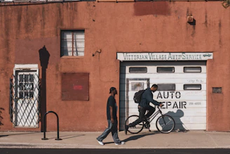 man in black jacket and blue denim jeans walking on sidewalk during daytime
